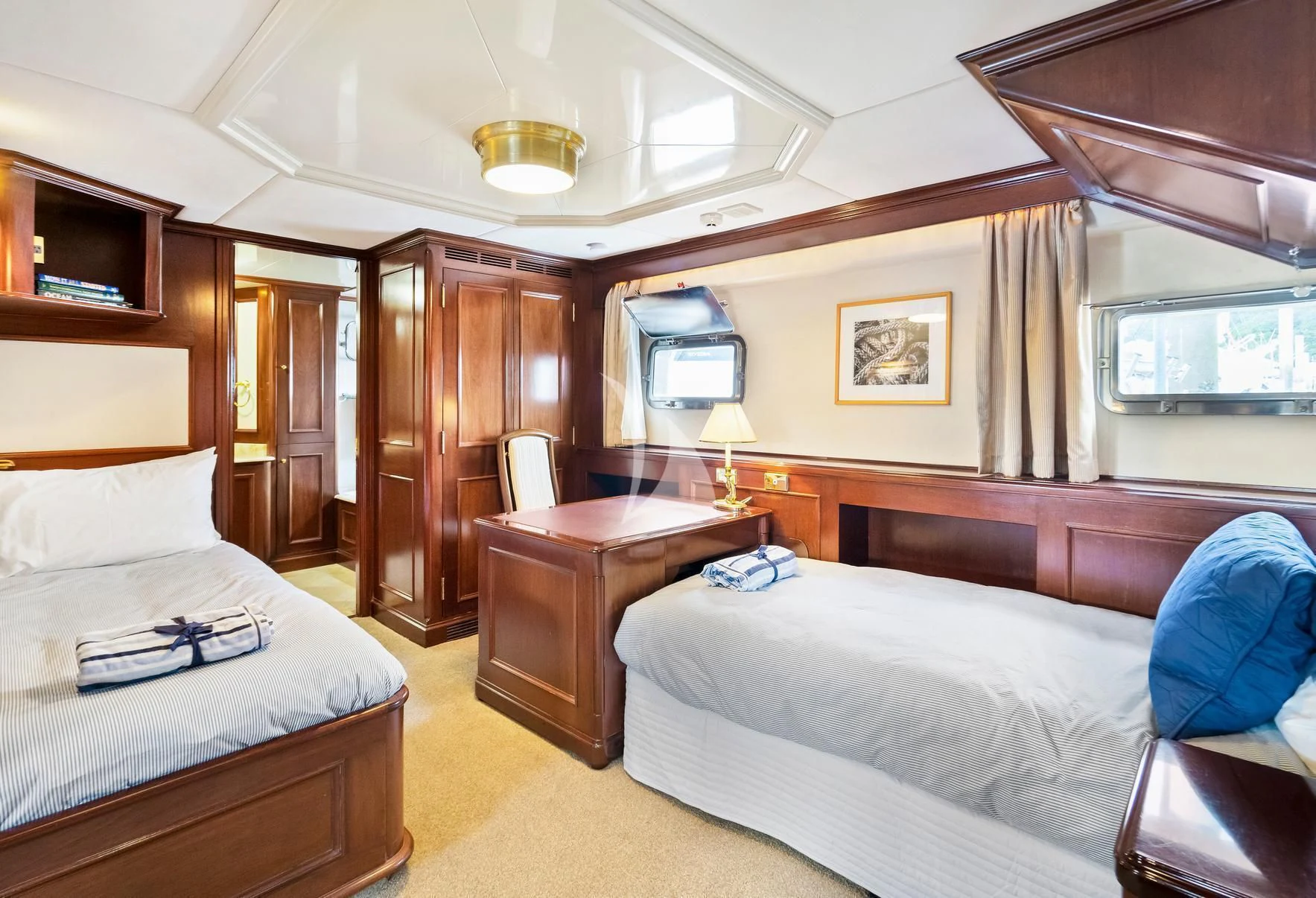 a bedroom with a bed and a desk aboard PACIFIC MERMAID Yacht for Sale