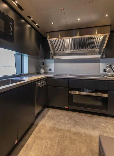 a kitchen with black cabinets aboard RUSH Yacht for Sale