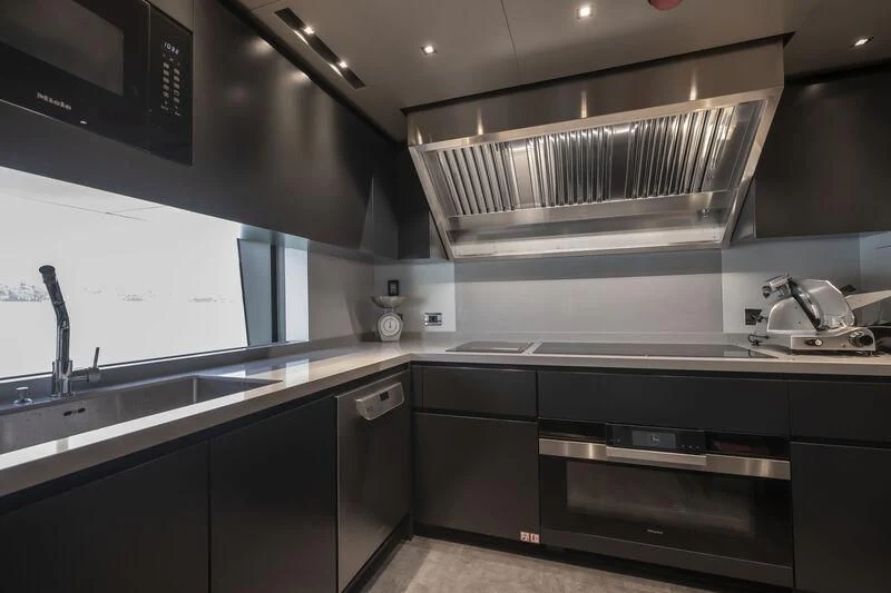 a kitchen with black cabinets aboard RUSH Yacht for Sale