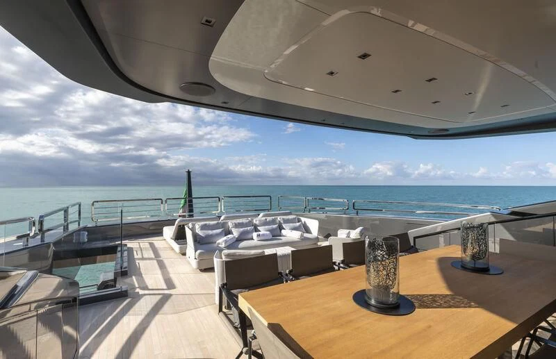 a room with a table and chairs on it by the ocean aboard RUSH Yacht for Sale