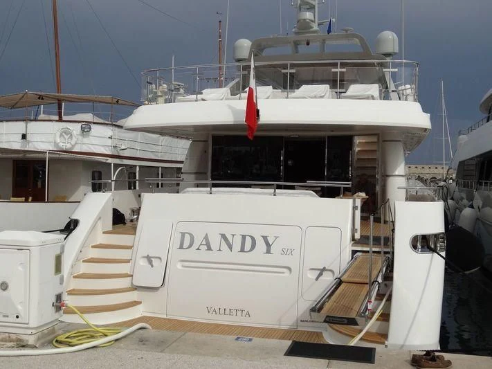 a large white boat with a red stripe on the front aboard DANDY SIX Yacht for Sale