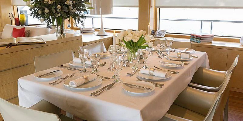a table set with plates and glasses aboard SALUTE Yacht for Sale