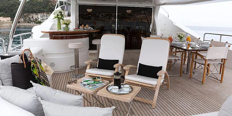 a room with a table chairs and a couch aboard SALUTE Yacht for Sale