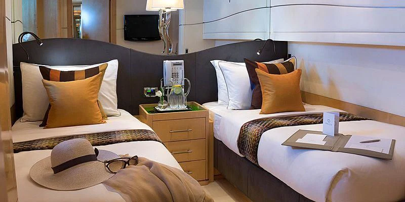 a hotel room with two beds aboard SALUTE Yacht for Sale