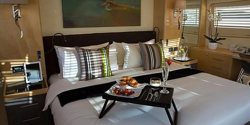 a bed with white sheets and pillows aboard SALUTE Yacht for Sale