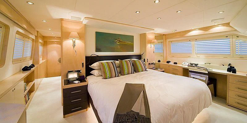a bedroom with a bed and desk aboard SALUTE Yacht for Sale
