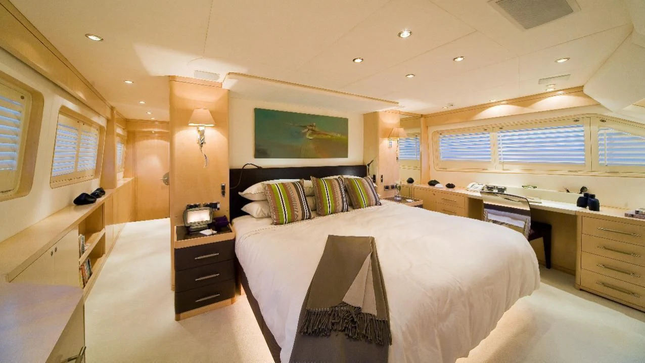 a bedroom with a bed and desk aboard SALUTE Yacht for Sale