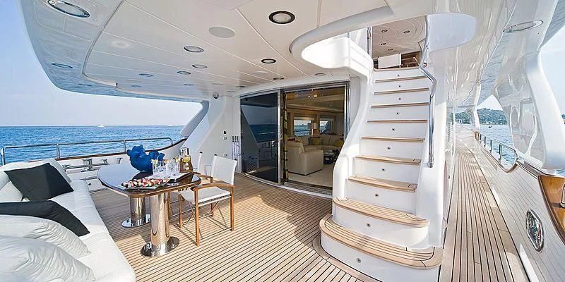 a room with a bed and a table and a window aboard SALUTE Yacht for Sale