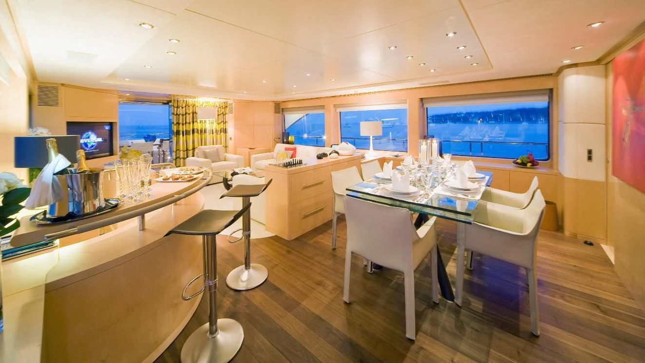a room with tables and chairs aboard SALUTE Yacht for Sale