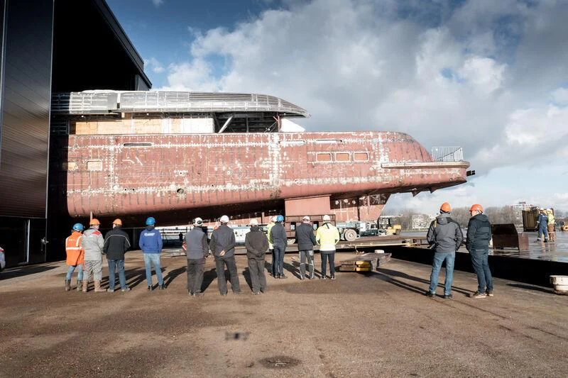 a group of people standing outside a large ship aboard B Yacht for Sale