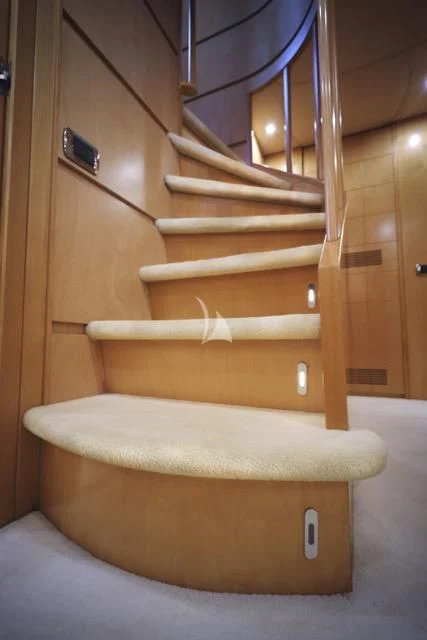 a wooden staircase with a metal railing aboard LADY A Yacht for Charter