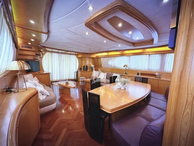 a large living room with a dining table and couches aboard LADY A Yacht for Charter