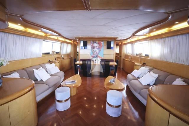 a room with a large television and a table with chairs aboard LADY A Yacht for Charter