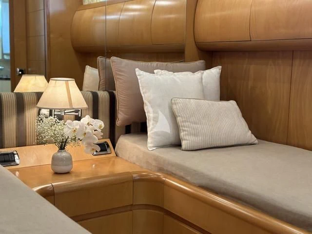a bed with pillows and a flower on the side aboard LADY A Yacht for Charter