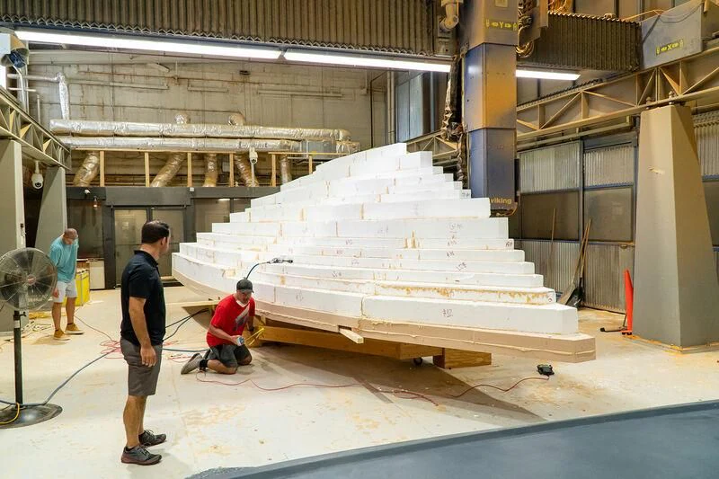 a group of people working on a white staircase in a factory aboard HEAVY ACTION Yacht for Sale