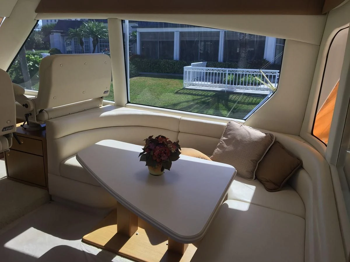 a room with a couch and a table with a plant in it aboard ONE MORE TIME Yacht for Sale
