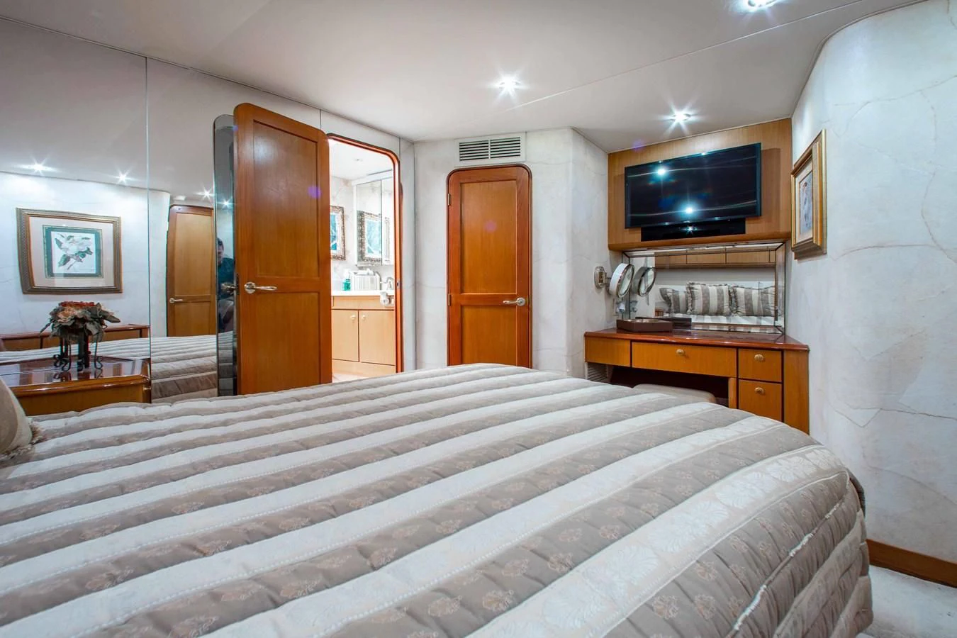 a bedroom with a bed and a tv on the wall aboard ONE MORE TIME Yacht for Sale