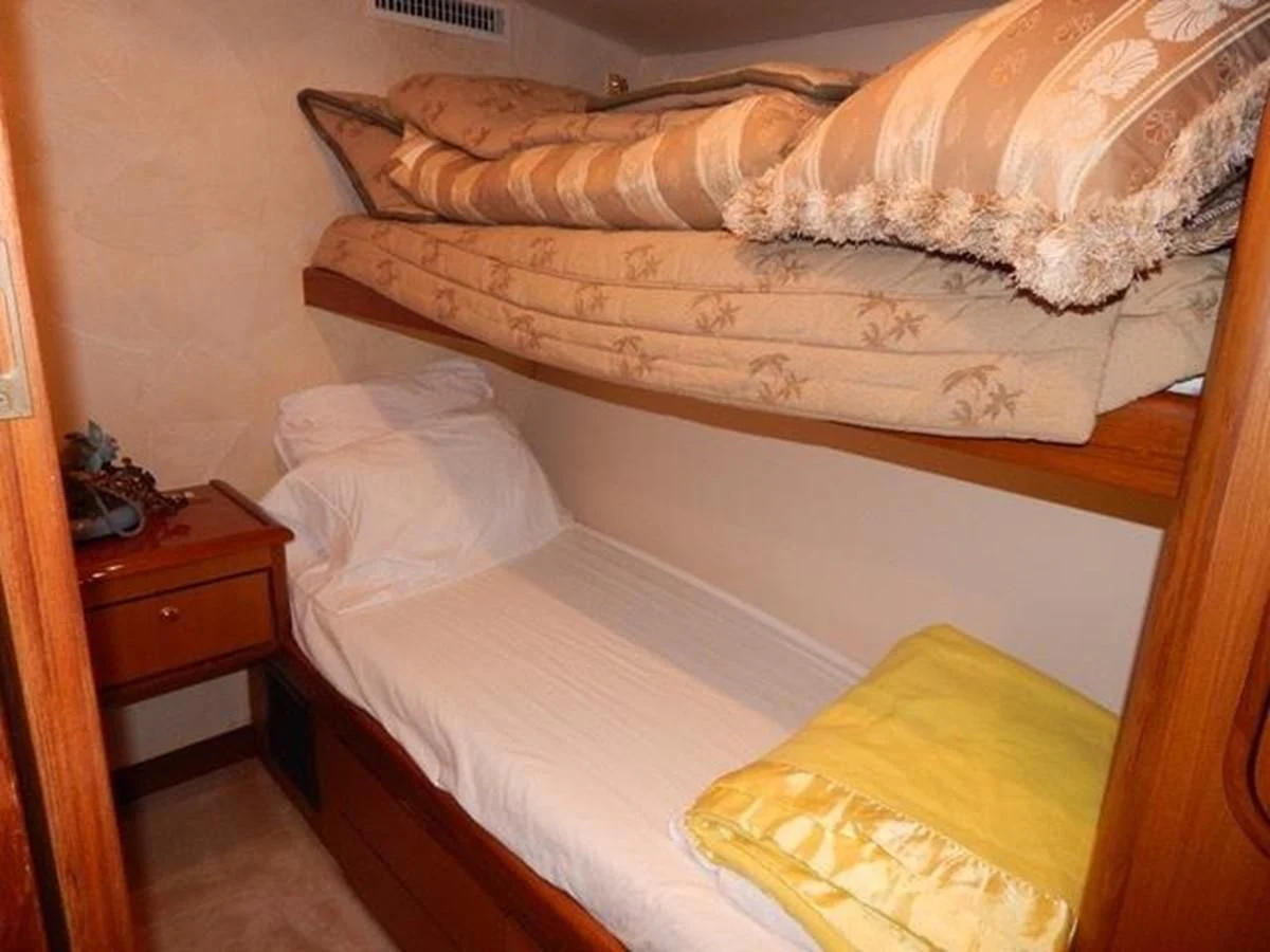 a bed with a wooden headboard aboard ONE MORE TIME Yacht for Sale