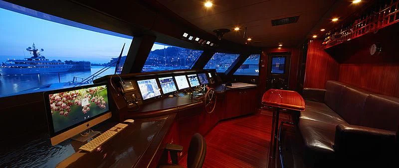 a room with a row of computers and a large ship in the background aboard FORWIN Yacht for Sale