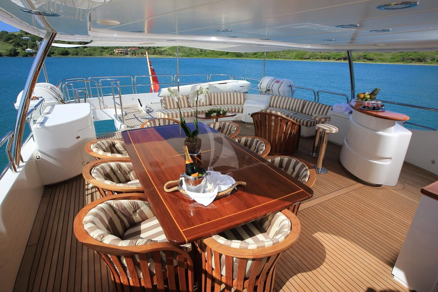 a table with chairs on it next to a body of water aboard NEW STAR Yacht for Charter