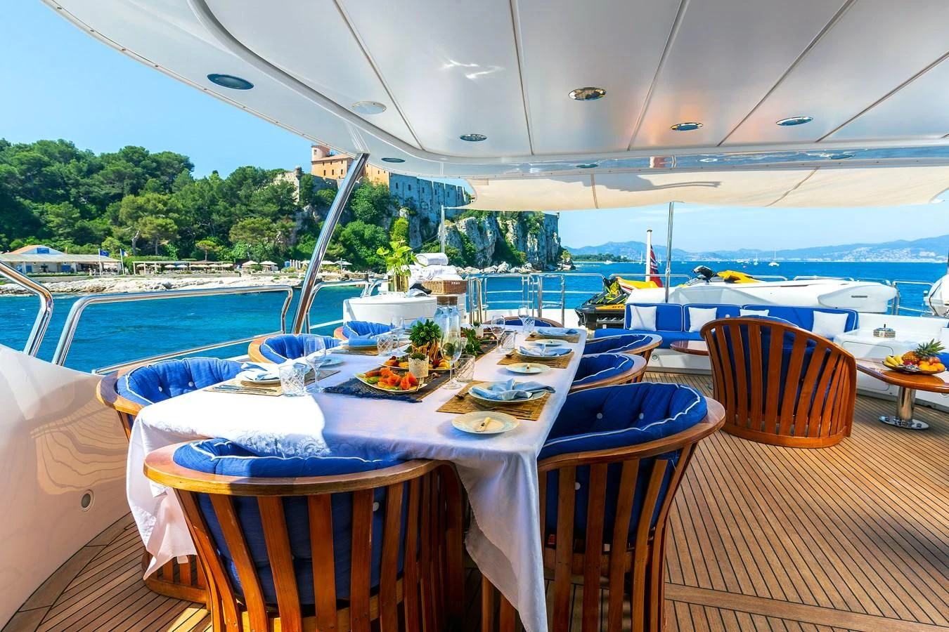 a table set for a meal on a deck overlooking a body of water aboard NEW STAR Yacht for Charter