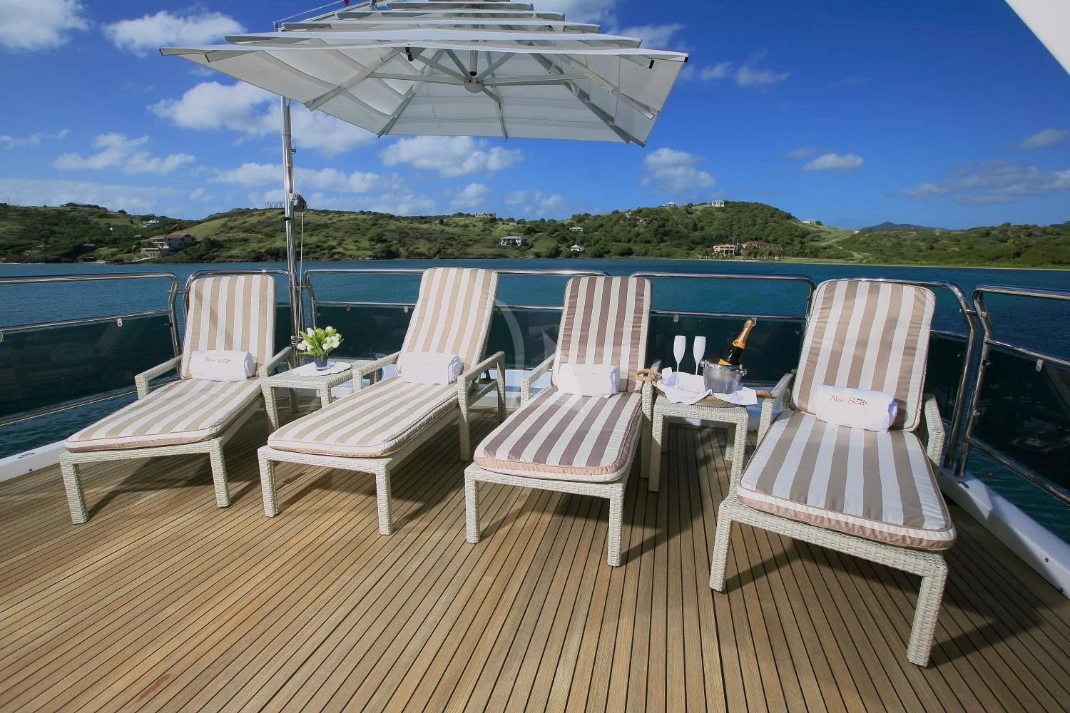 a deck with chairs and a table on it aboard NEW STAR Yacht for Charter