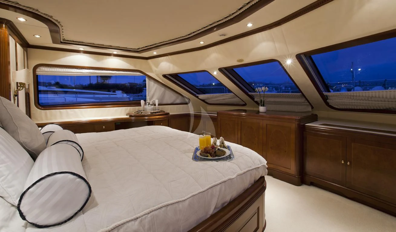 a bed with a tray of food and a television in the background aboard NEW STAR Yacht for Charter
