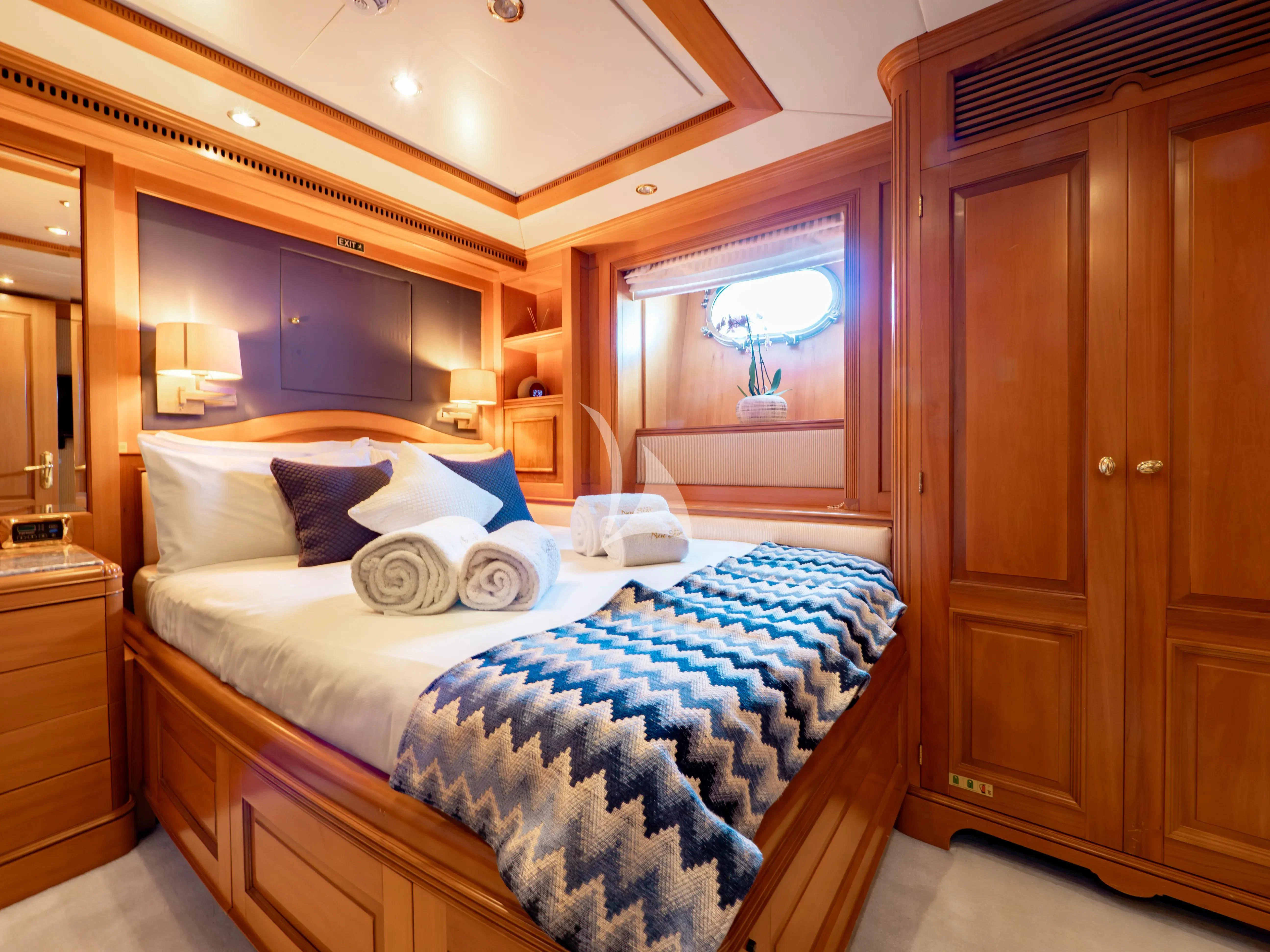 a bedroom with a bed and a mirror aboard NEW STAR Yacht for Charter