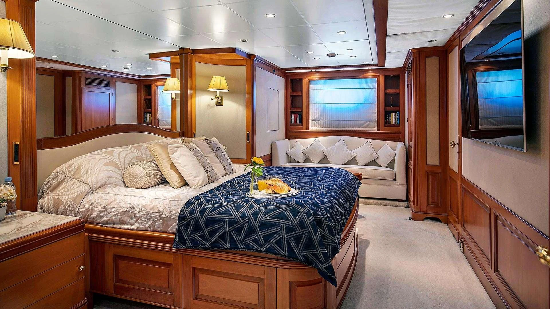 a room with a bed and a television aboard NEW STAR Yacht for Charter