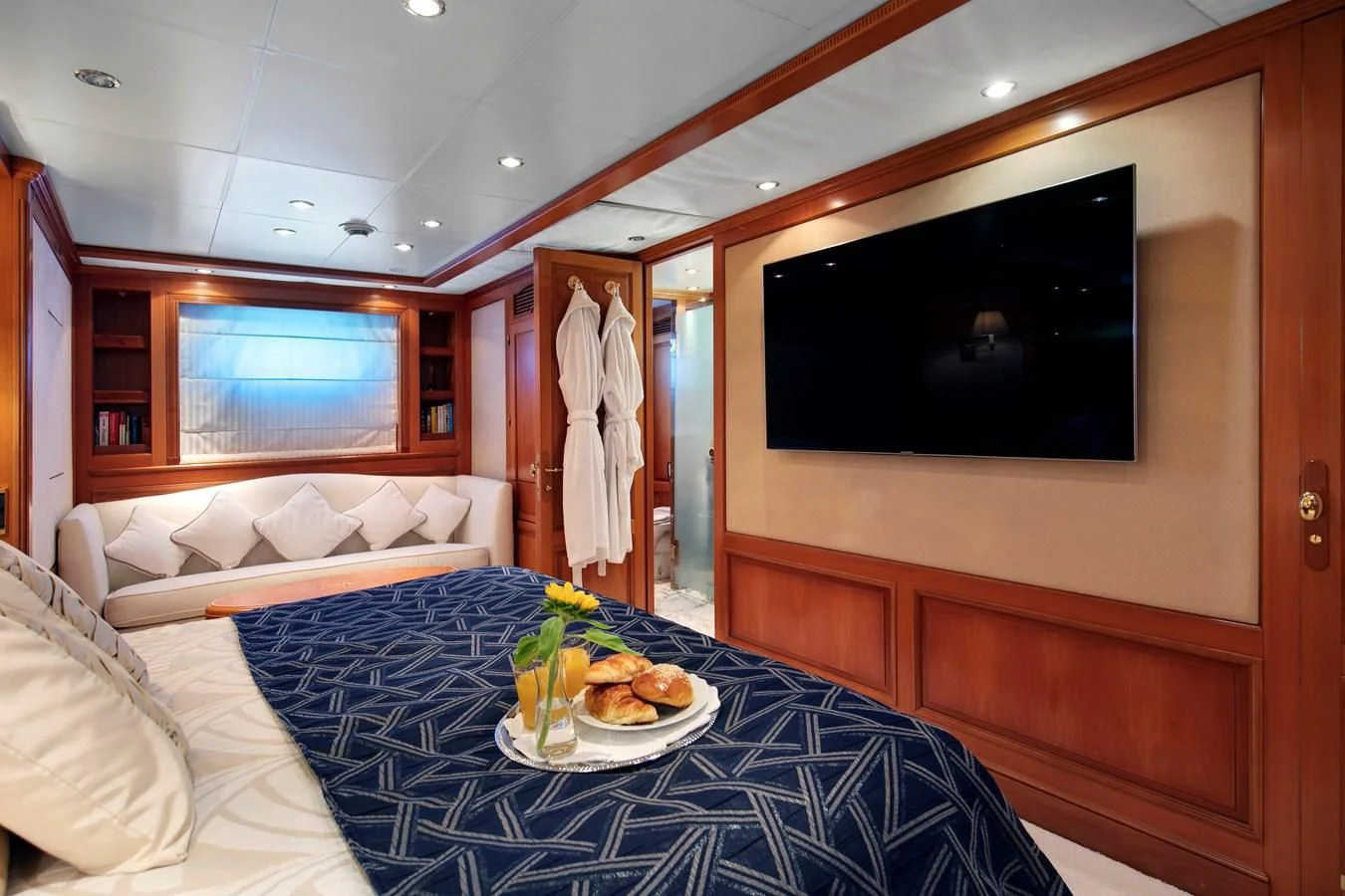 a room with a bed and a television aboard NEW STAR Yacht for Charter