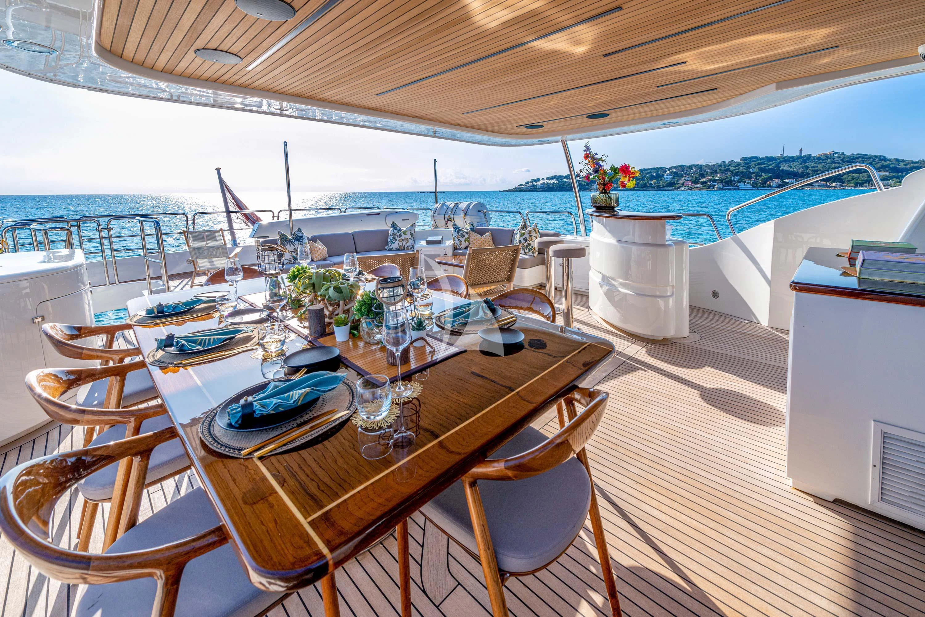 a table with chairs and a view of the ocean aboard NEW STAR Yacht for Charter