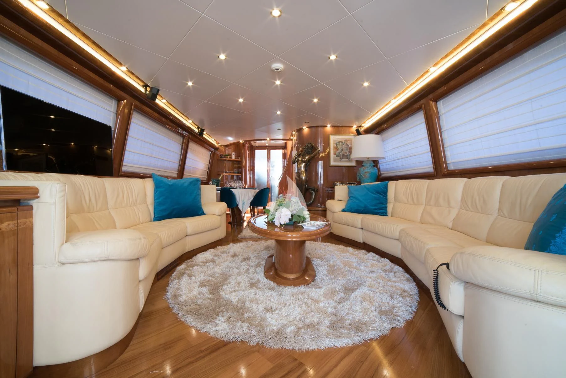 a living room with a large white couch and a round table aboard D'ARISTOTELIS Yacht for Sale