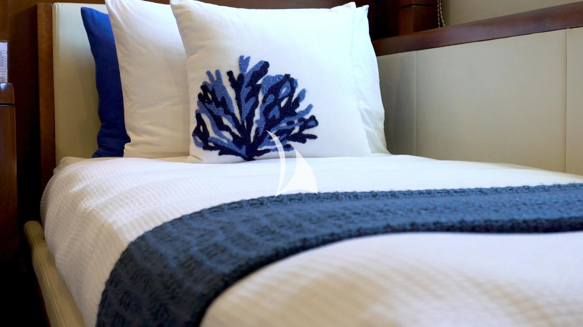 a bed with a blue pillow aboard MASTEKA 2 Yacht for Charter