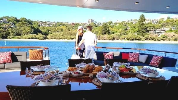 a couple of people standing by a table with food on it aboard MASTEKA 2 Yacht for Charter