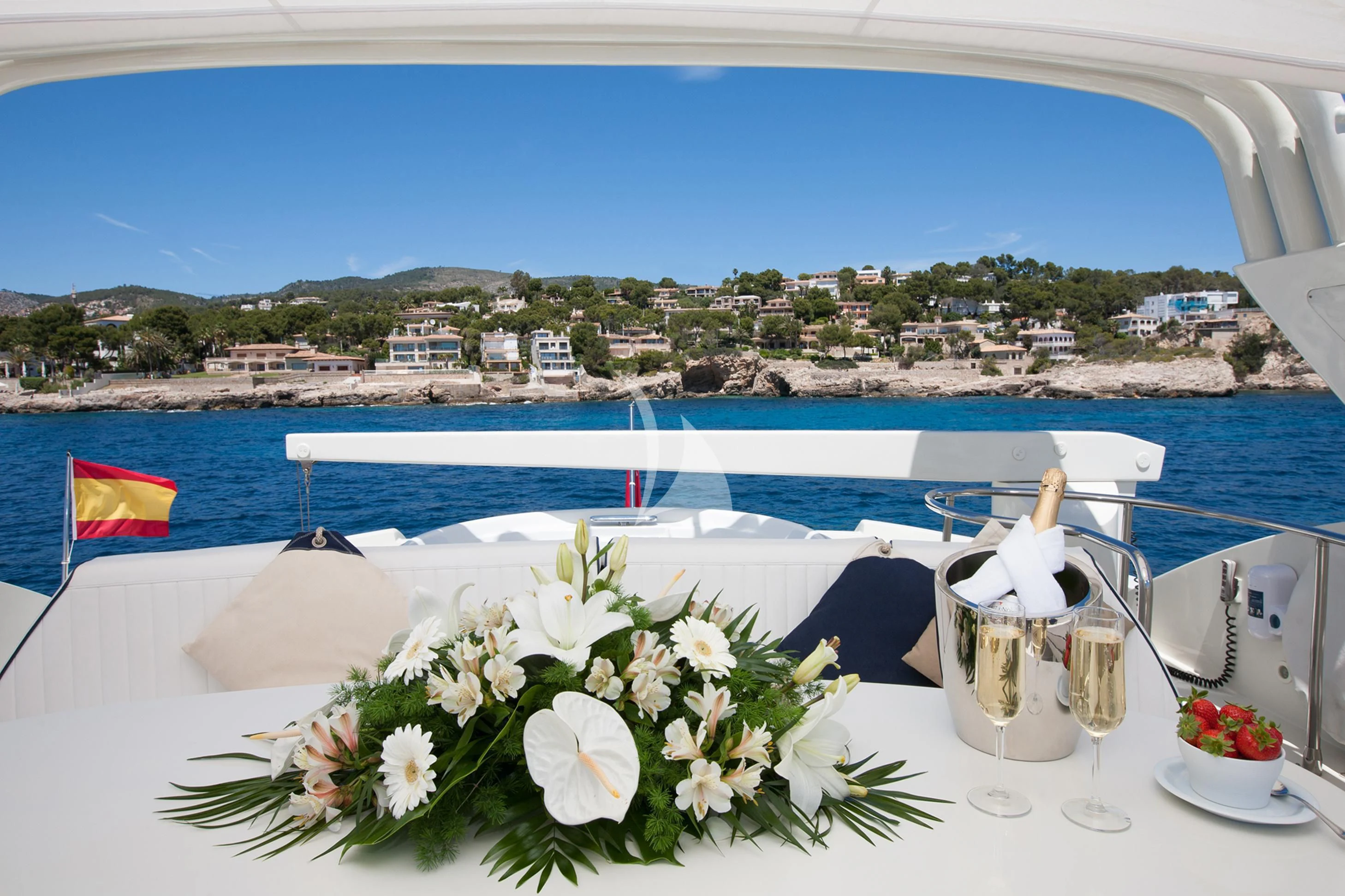 a table with a glass and flowers on it by a body of water aboard WHITE FANG Yacht for Sale