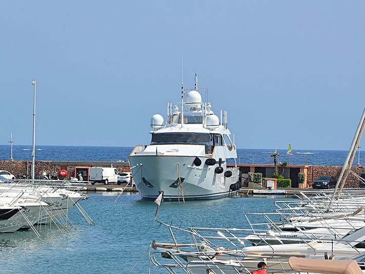 a large white boat in a harbor aboard JAMEEL Yacht for Sale