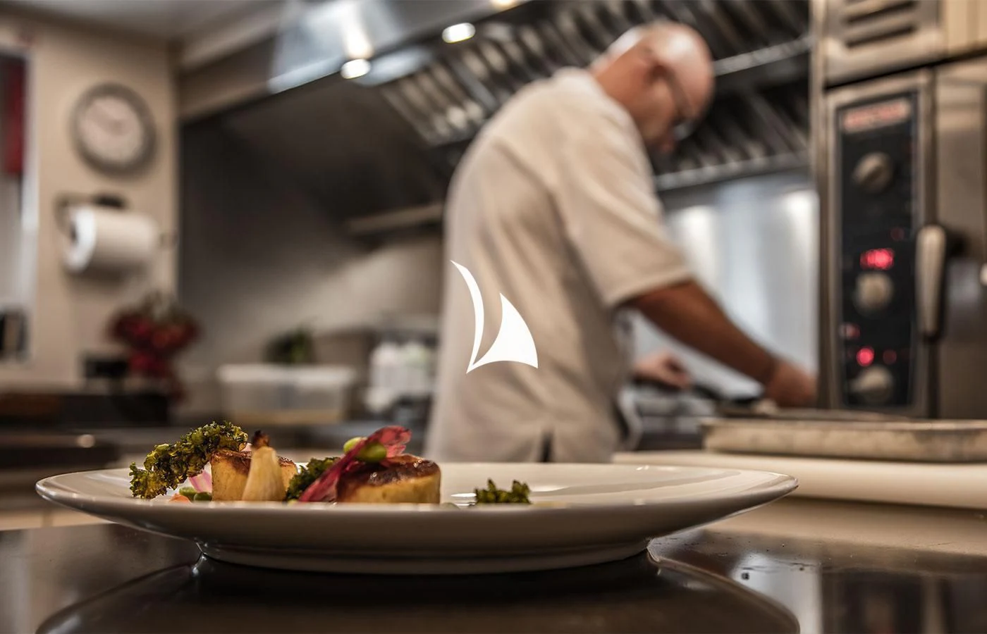 a chef preparing food in a kitchen aboard SEVERIN°S Yacht for Charter