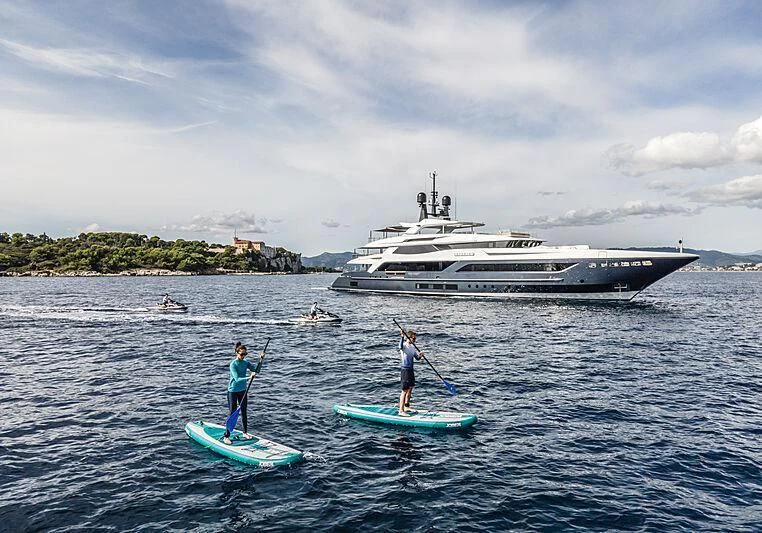 a couple of people paddle boarding in the ocean aboard SEVERIN°S Yacht for Charter