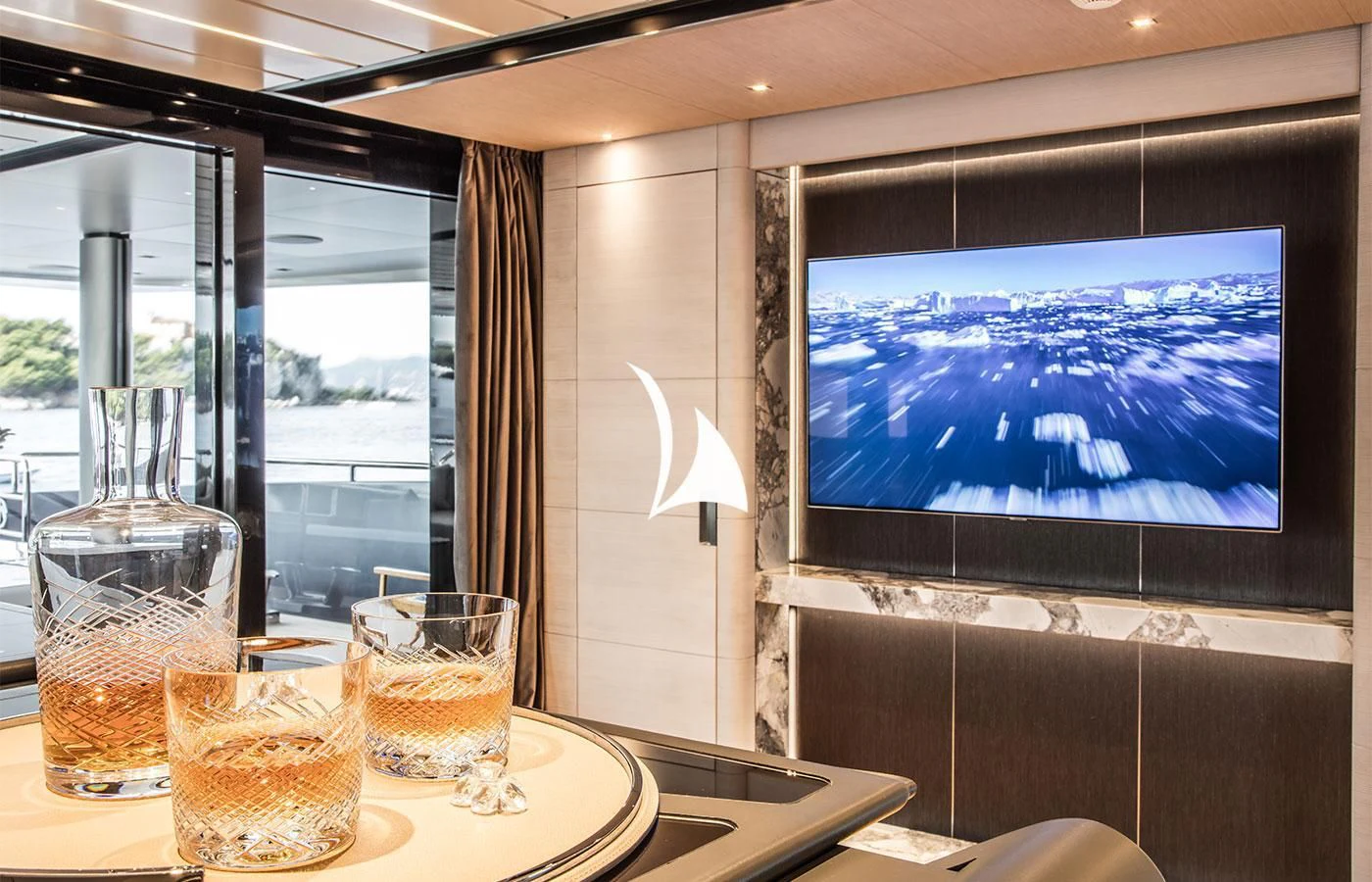 a table with a television and glasses on it aboard SEVERIN°S Yacht for Charter
