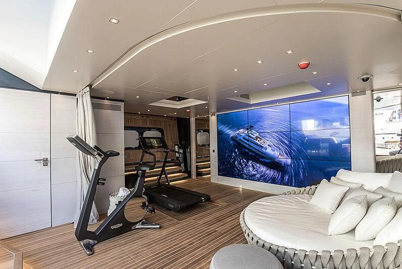 a room with a large window and a couch and a large blue screen aboard SEVERIN°S Yacht for Charter