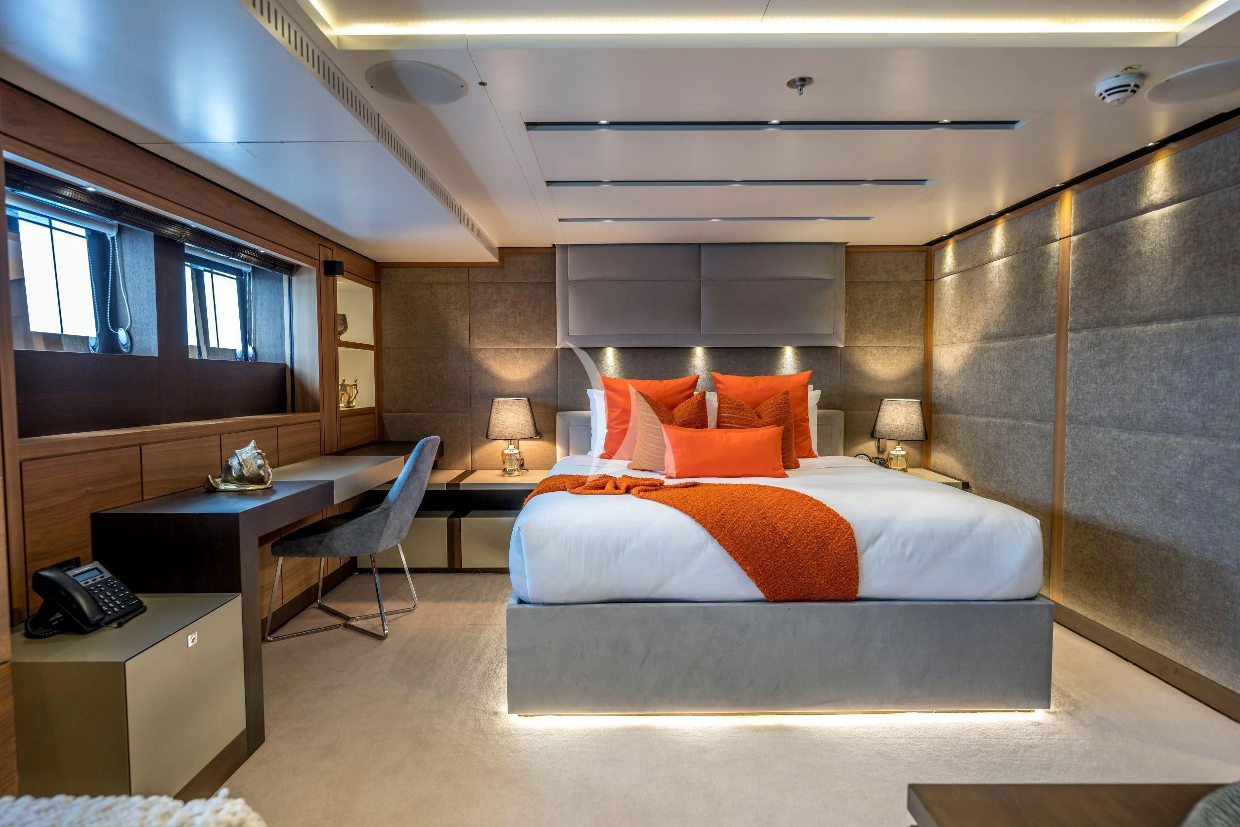 a hotel room with a bed and desk aboard NAVIS ONE Yacht for Charter