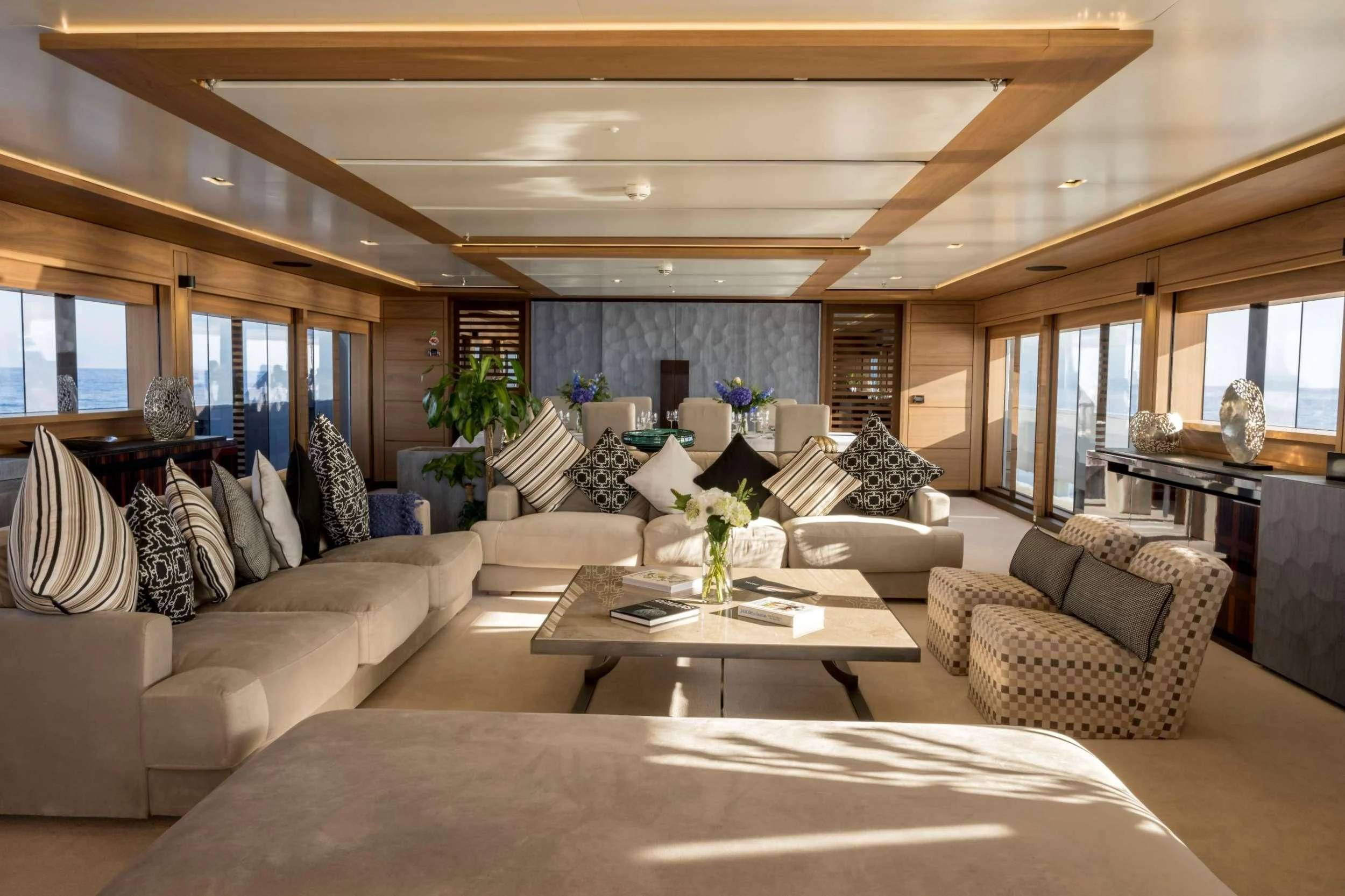 a living room with a large white couch and a large window aboard NAVIS ONE Yacht for Charter