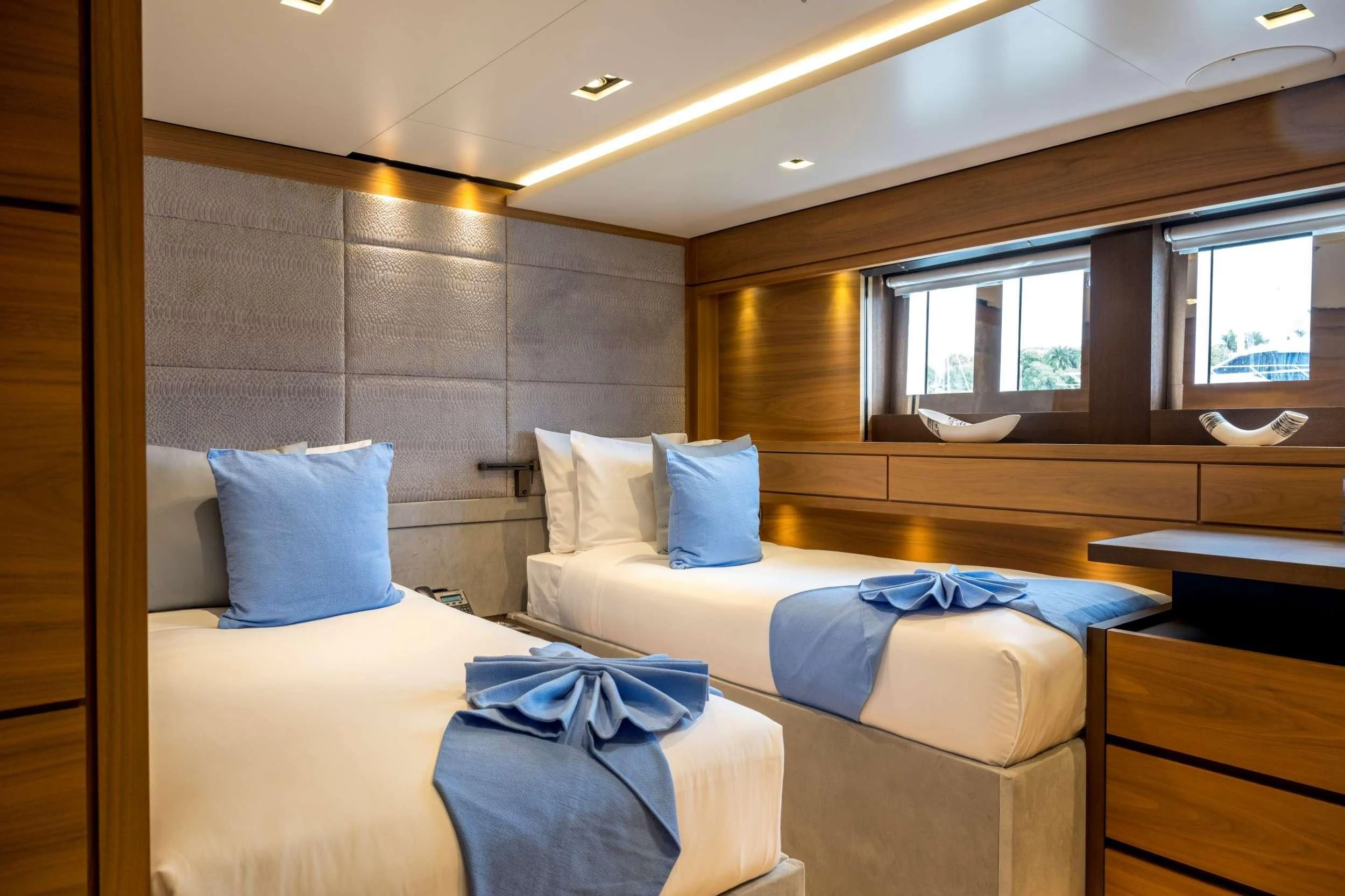 a room with beds and a window aboard NAVIS ONE Yacht for Charter