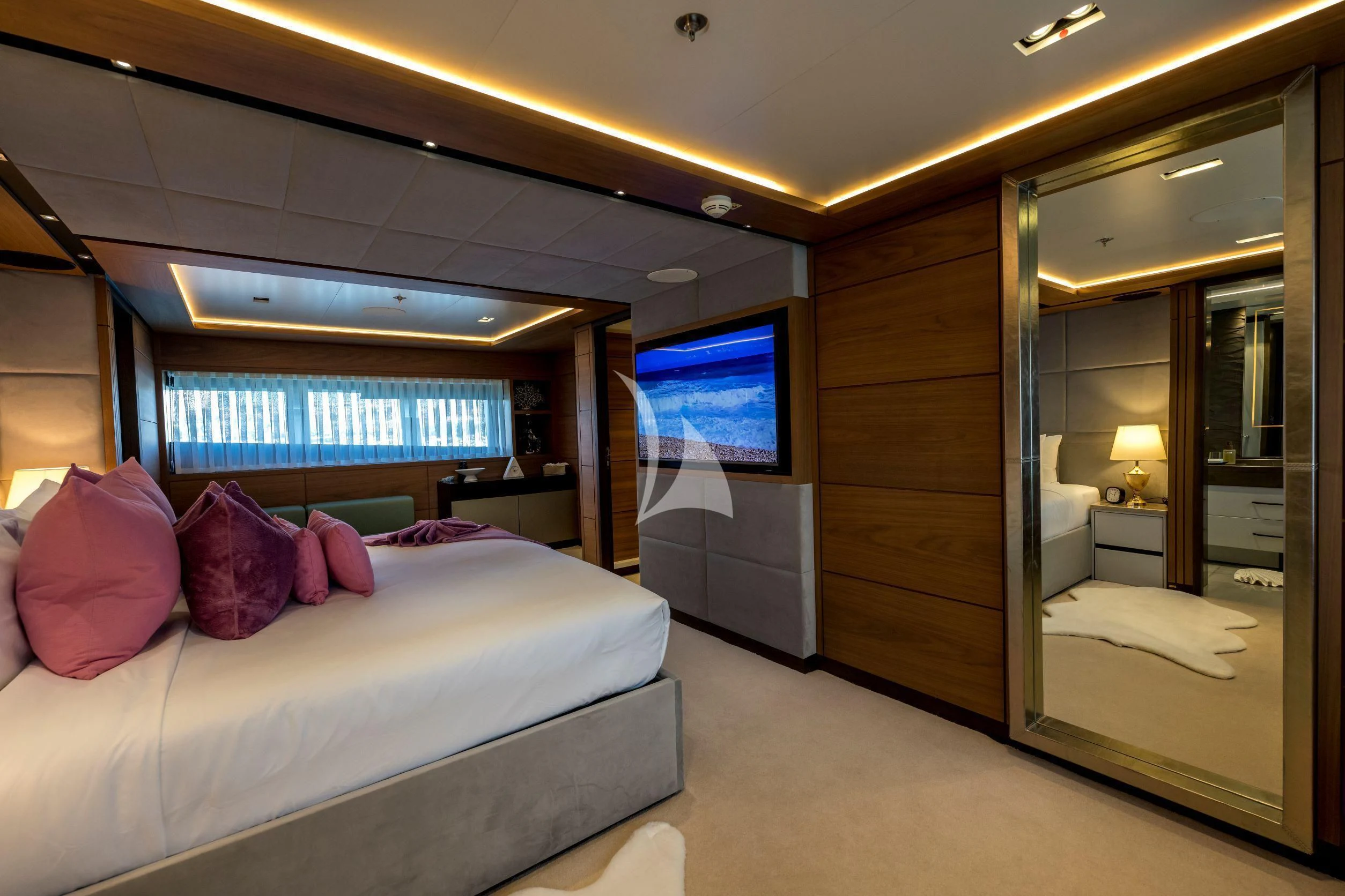a bedroom with a bed and a tv on the wall aboard NAVIS ONE Yacht for Charter