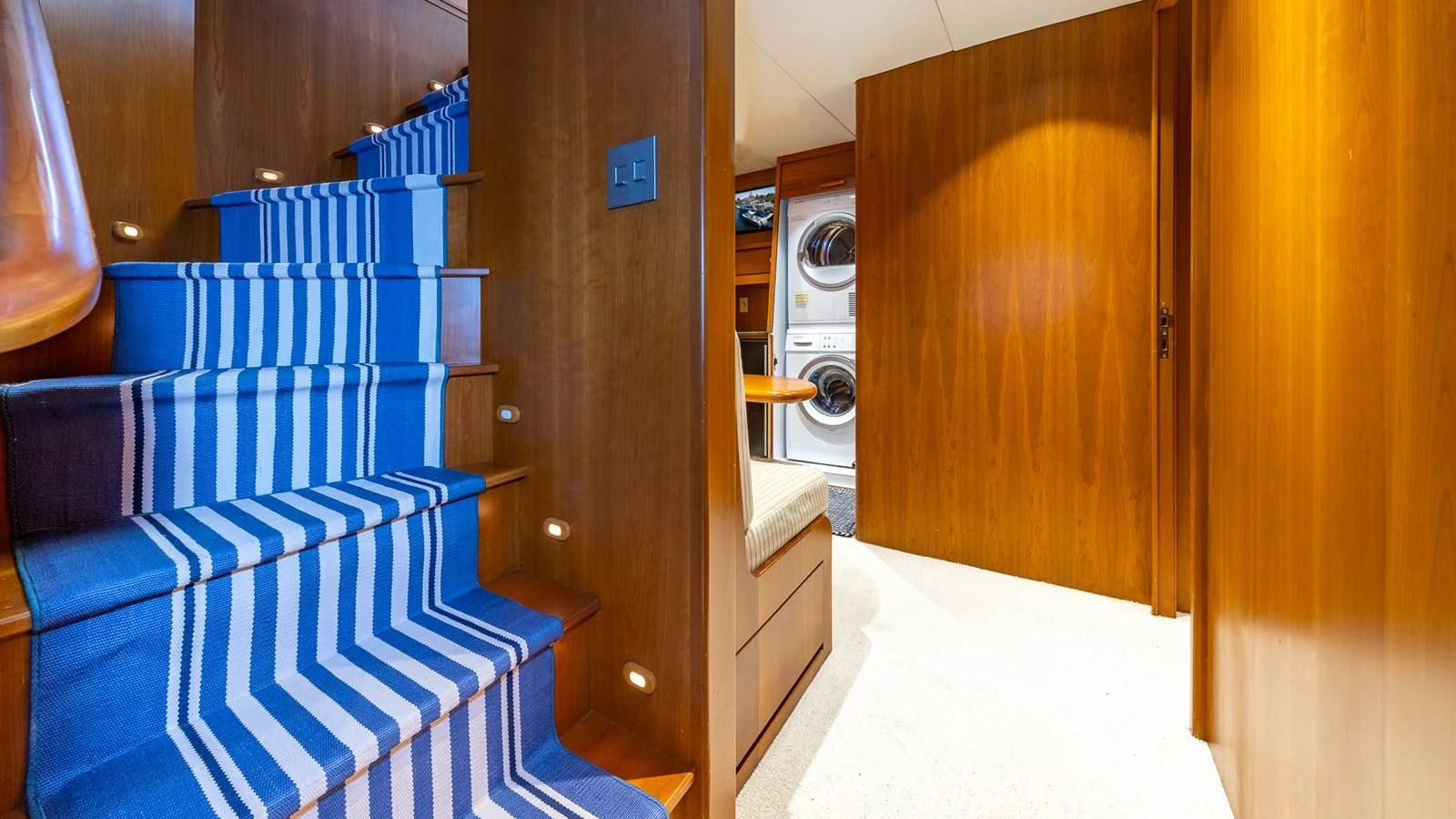 a room with a blue bed and wooden closet aboard SEAQUEL Yacht for Sale
