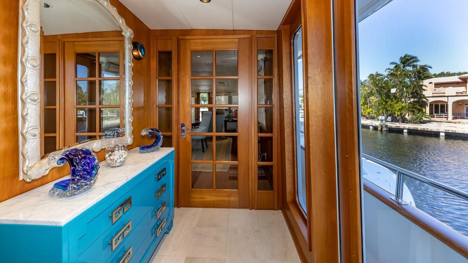 a room with a glass door and a pool table with chairs and a window with a view of aboard SEAQUEL Yacht for Sale