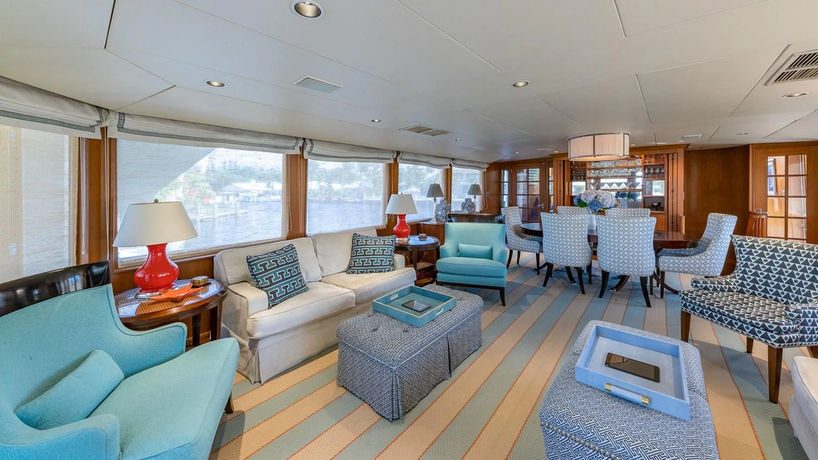 a living room with blue chairs and a table aboard SEAQUEL Yacht for Sale