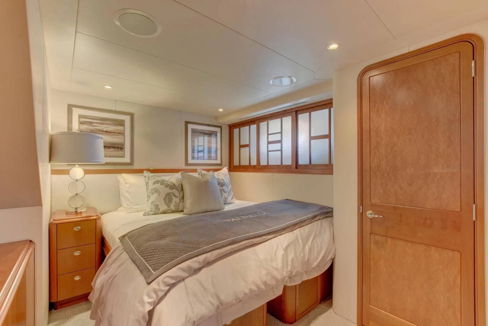 a bedroom with a bed and a wooden door aboard GOOD TIMES Yacht for Sale