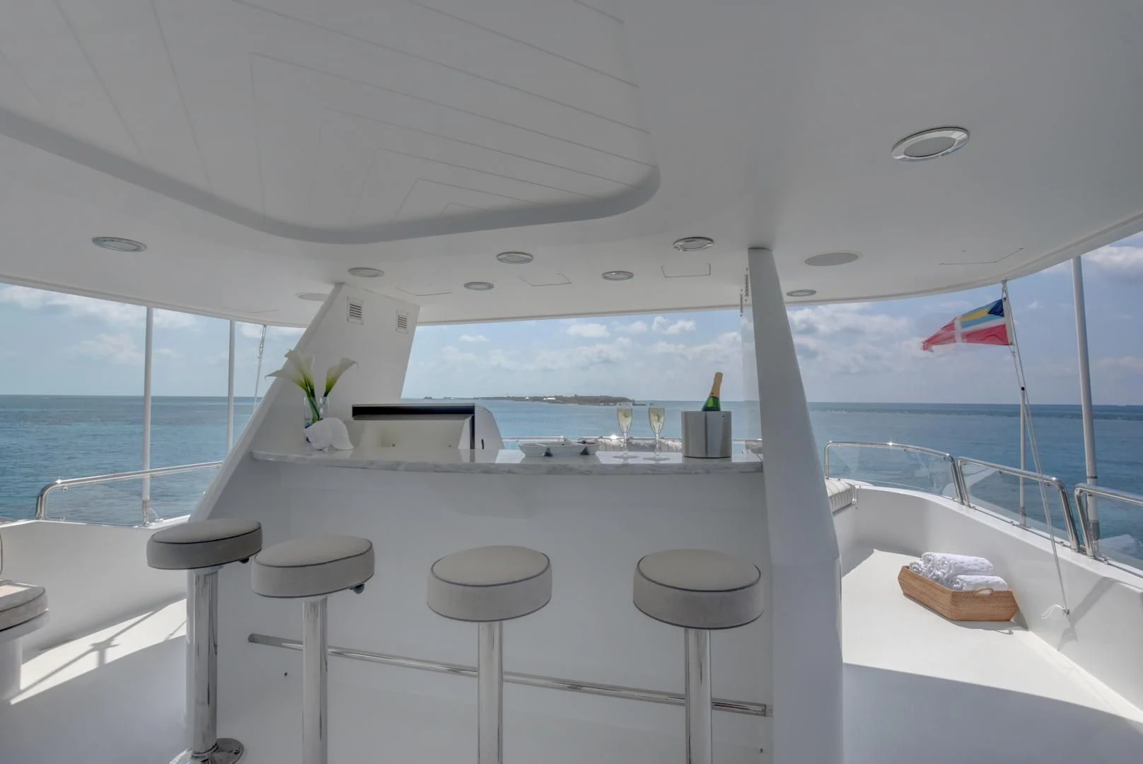 a room with a table and stools and a view of the ocean aboard GOOD TIMES Yacht for Sale