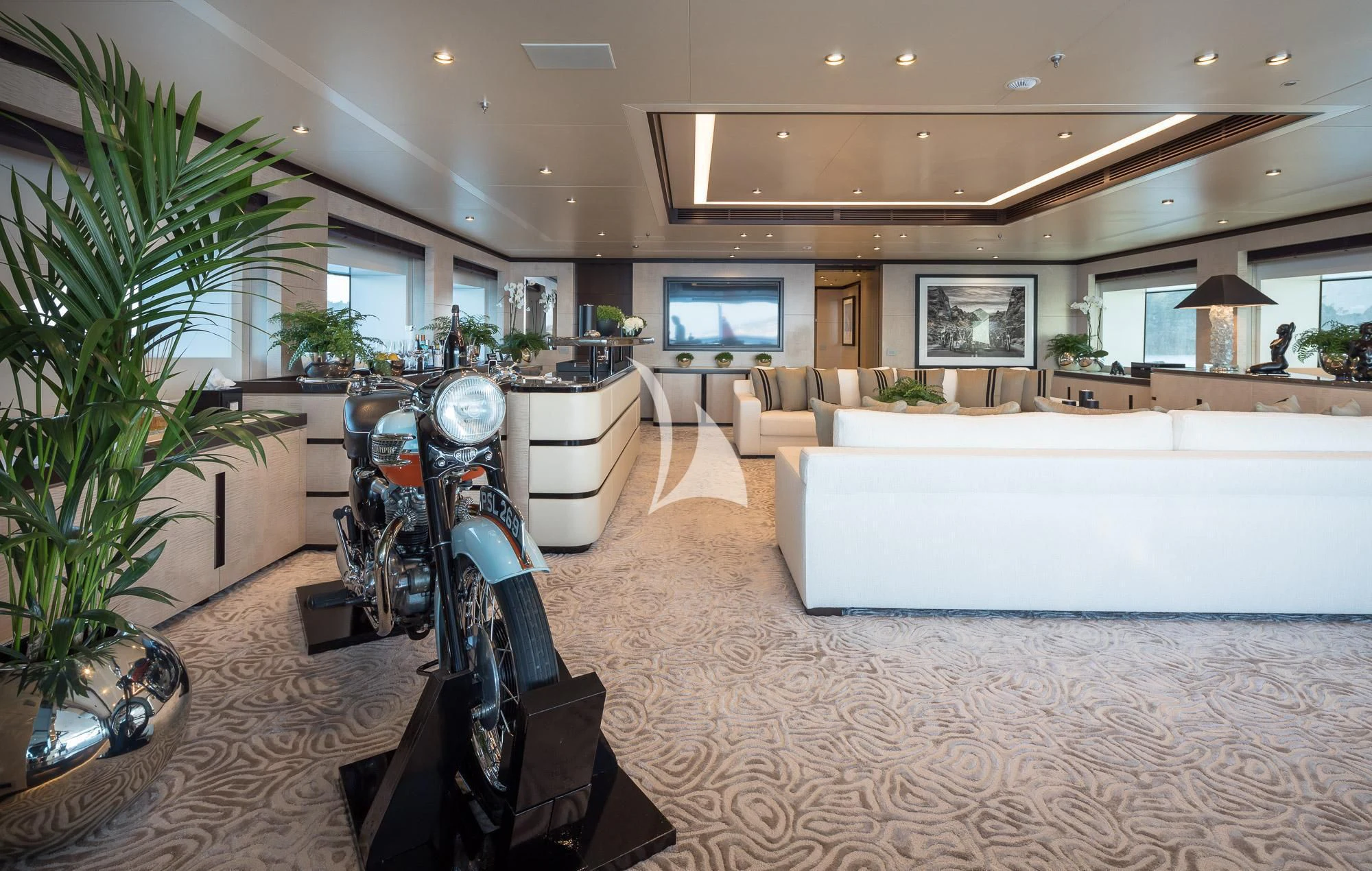 a living room with a large white sofa and a large screen aboard TRIUMPH Yacht for Sale